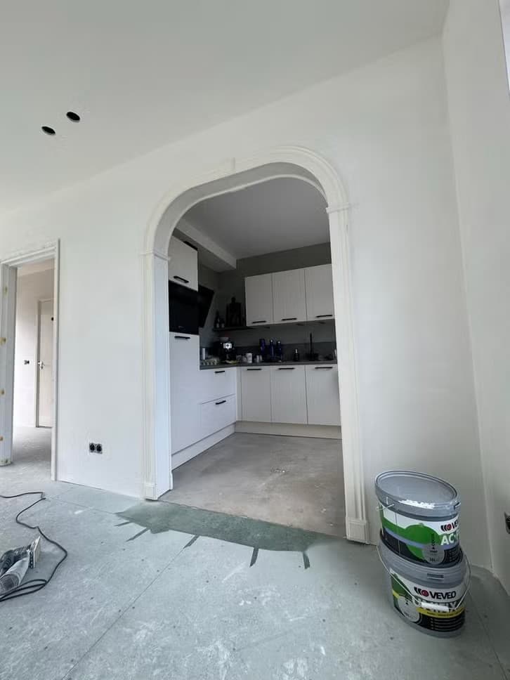 Afgewerkte woonkamer met doorgang naar de keuken